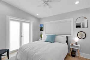 Queen bed with luxurious linens and bedside lighting.