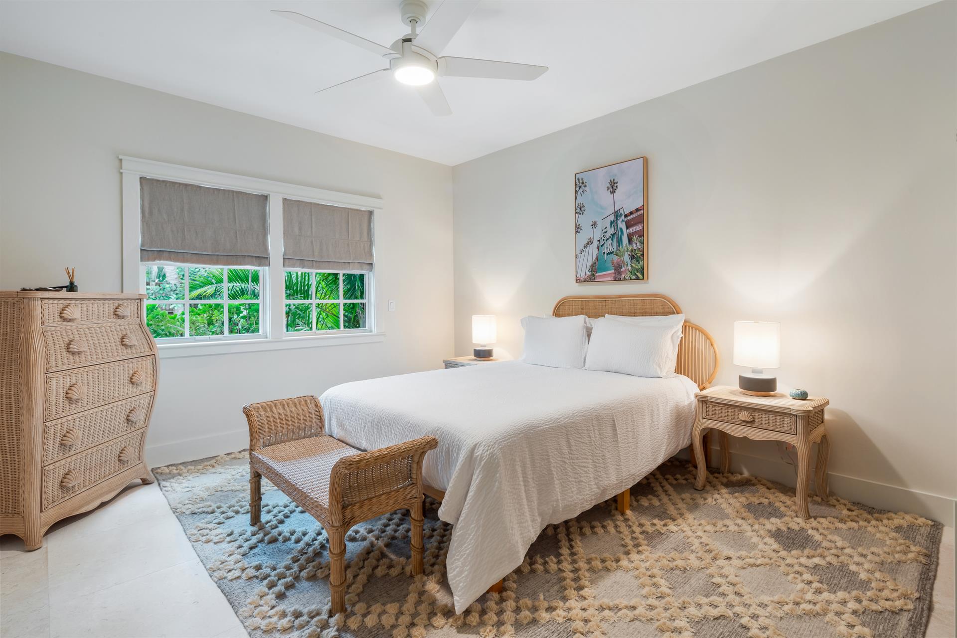 First floor queen bedroom with dresser, TV, and ceiling fan.