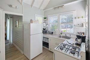 View of kitchen and hallway leading back to bedroom.