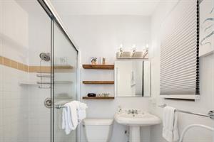 Ensuite bath has tiled walk in shower and pedestal sink