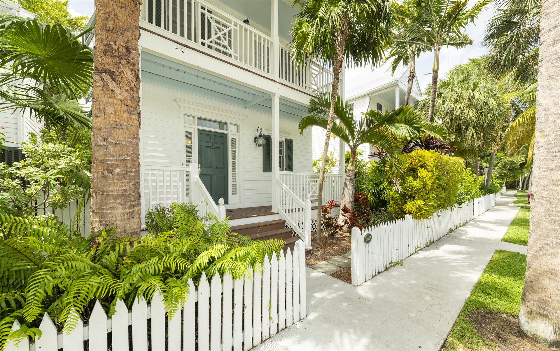 Lush landscaping and a picket fence surround you