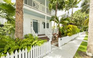 Lush landscaping and a picket fence surround you