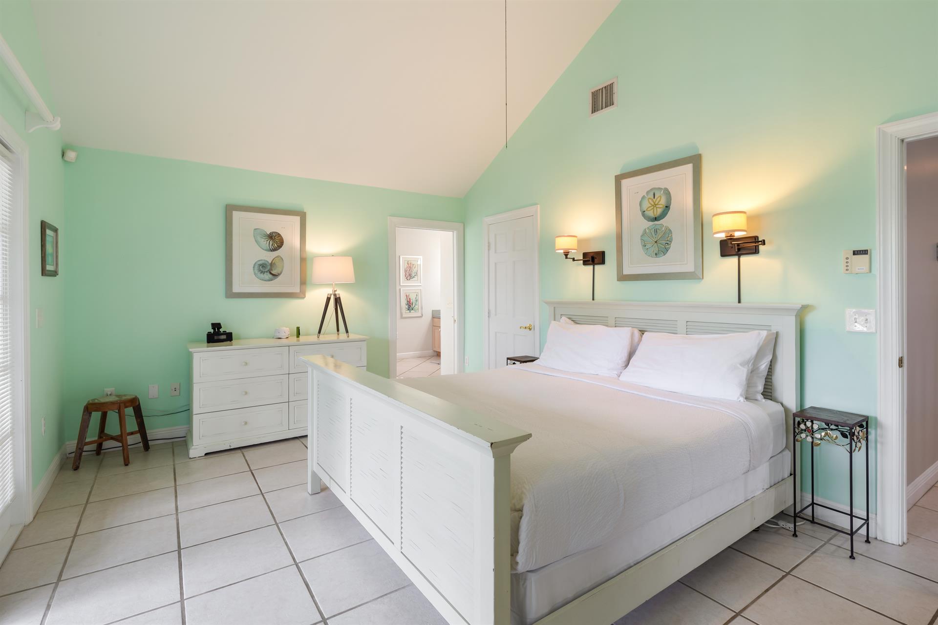 Primary ensuite with king bed and dresser.