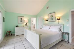 Primary ensuite with king bed and dresser.