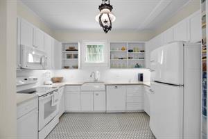 Crisp clean kitchen with retro fridge and plenty of storage