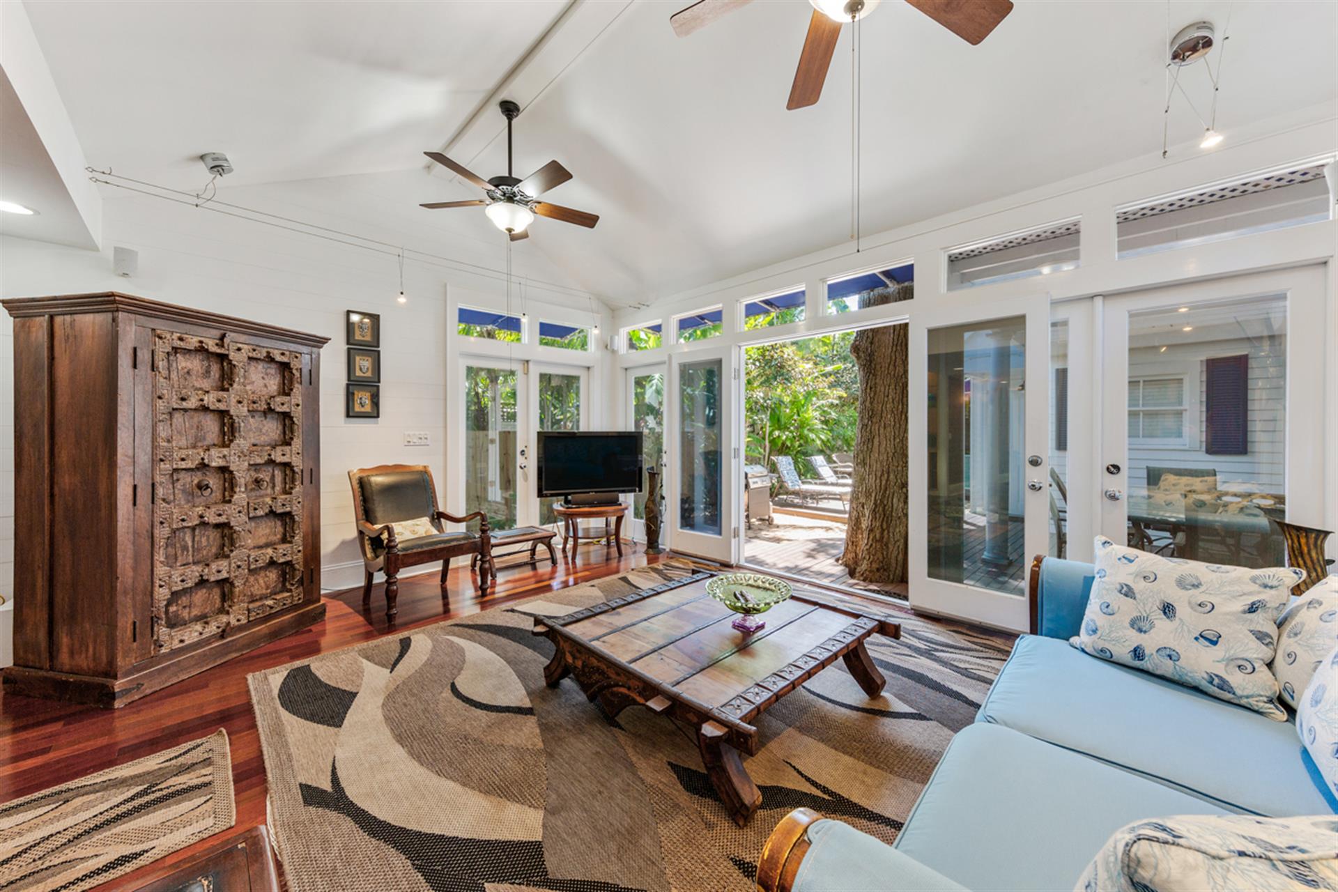 Living room includes vaulted ceilings with dual ceiling fans.