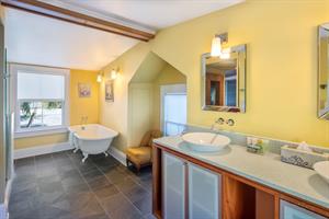 Primary bathroom with clawfoot tub and double vanity.