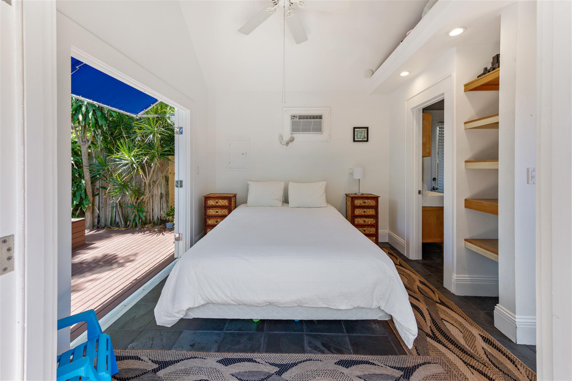 Pool house bedroom with ensuite half bath and outdoor shower
