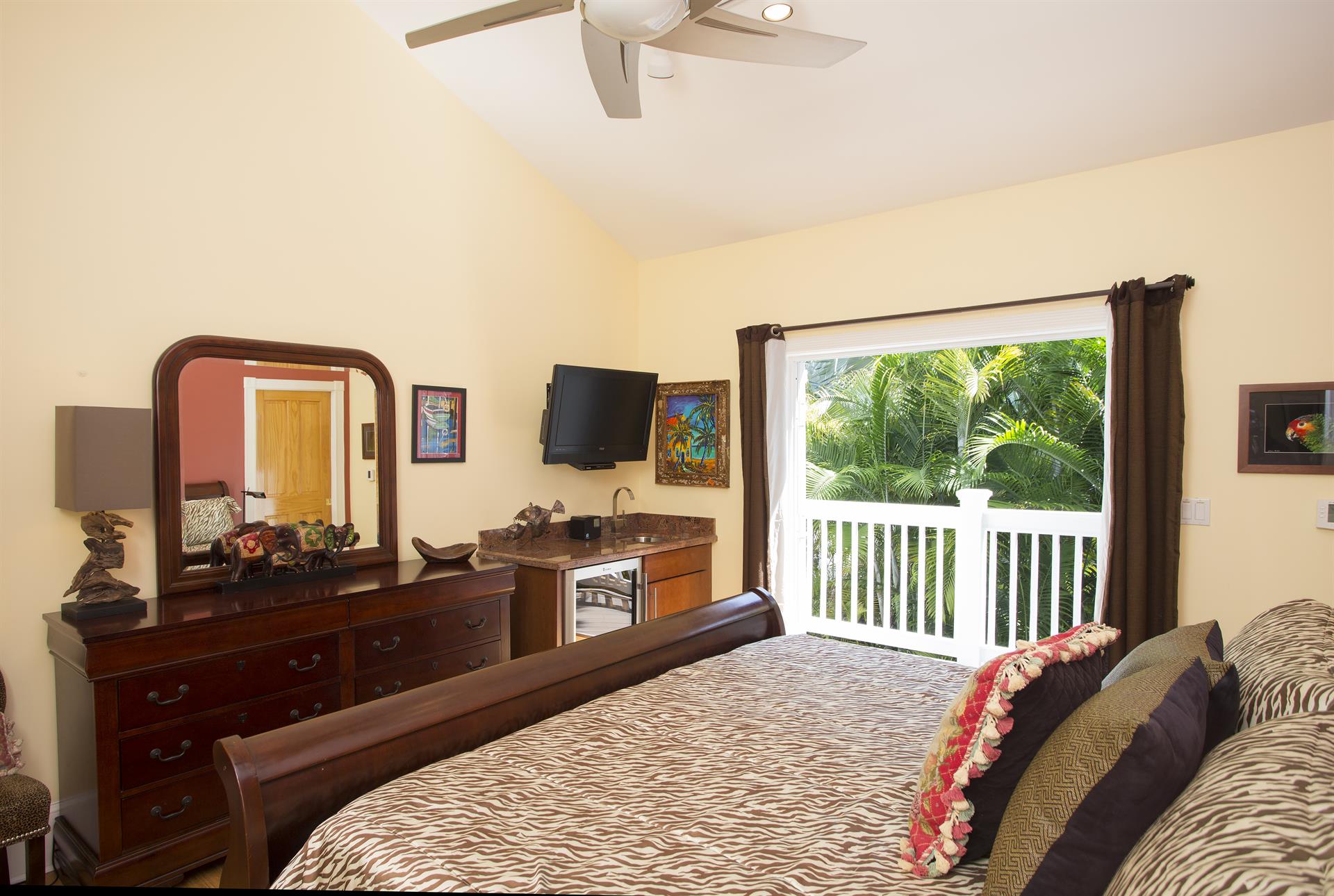Primary king ensuite bedroom with wet bar and garden view
