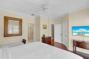 Primary suite with ceiling fan, TV and closet.