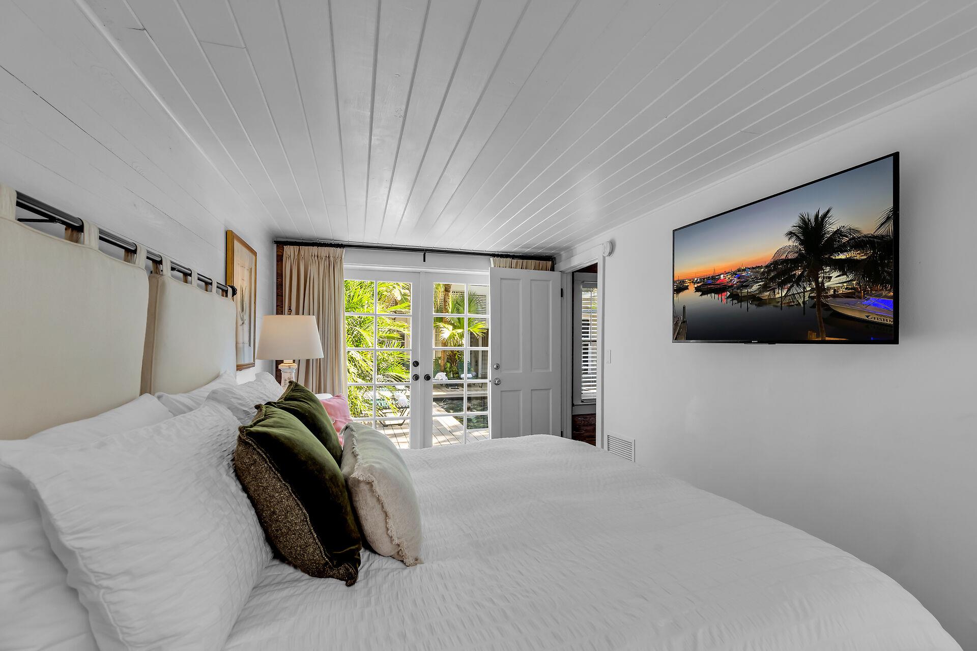 Luxurious linens, bedside lighting, and TV in the primary