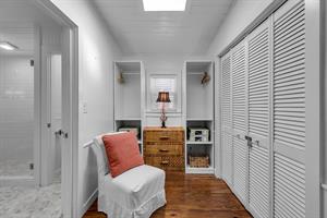 Great primary closet area with slipper chair