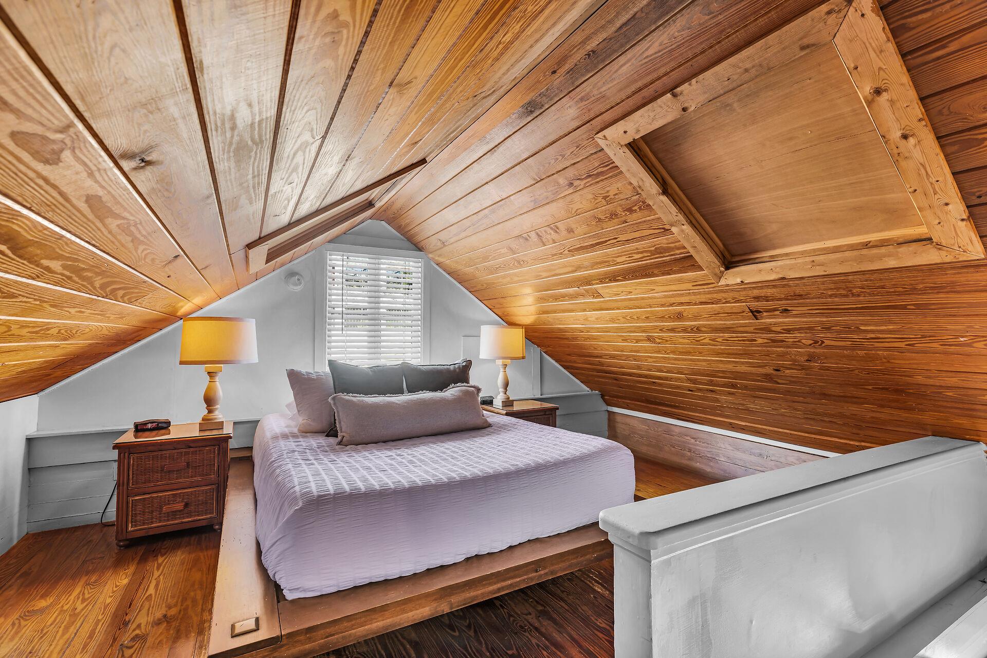 Queen bed in open loft with bedside lighting