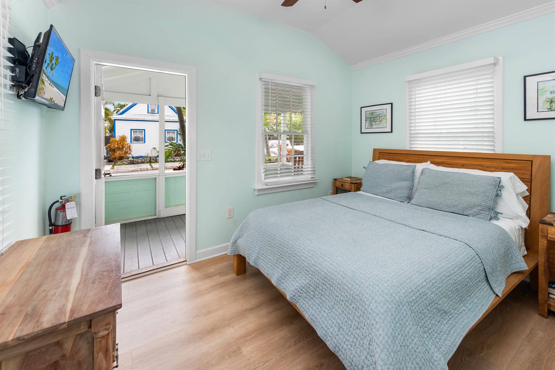 Queen bed with TV, dresser and porch access