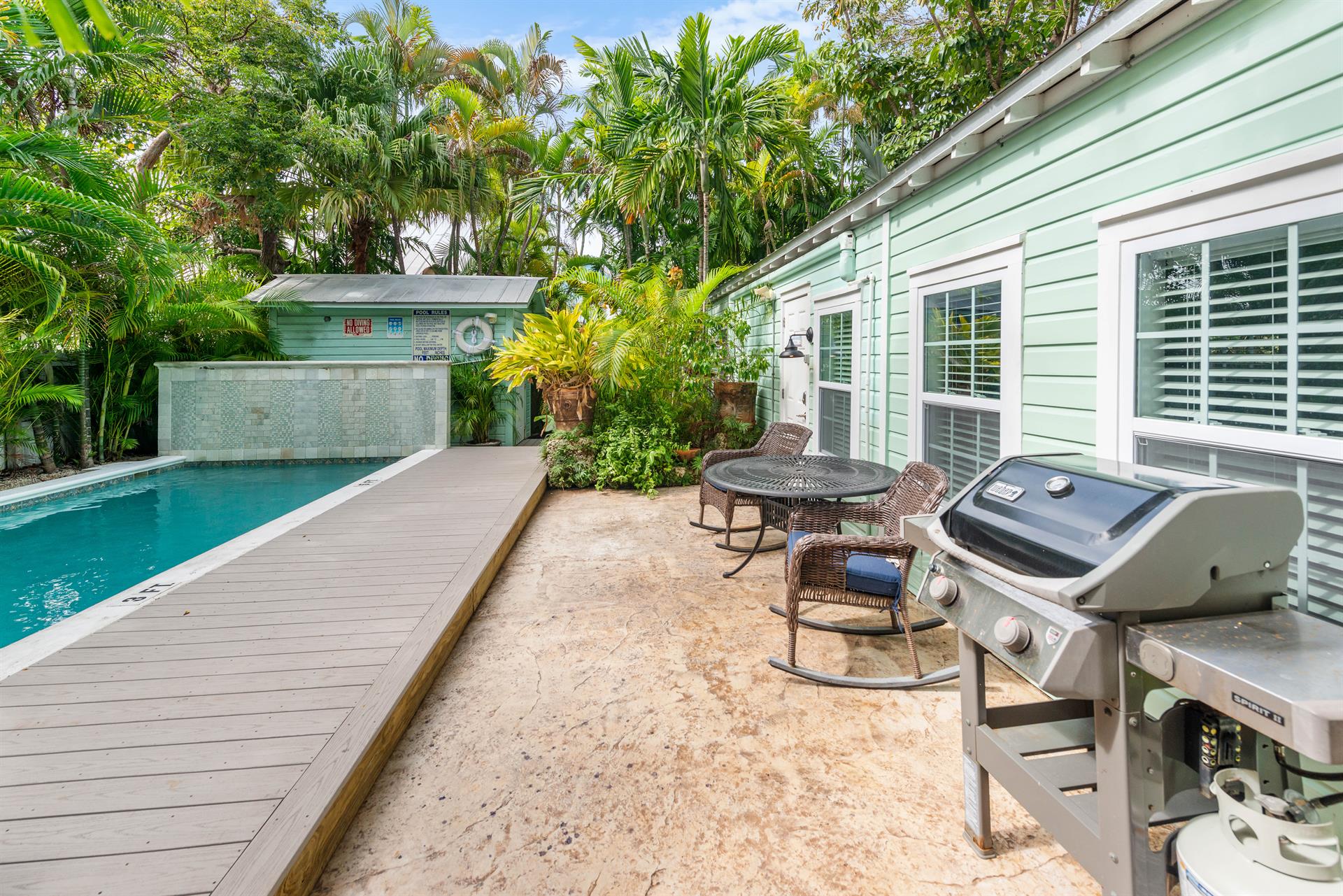 Dining set and grill just steps from the pool