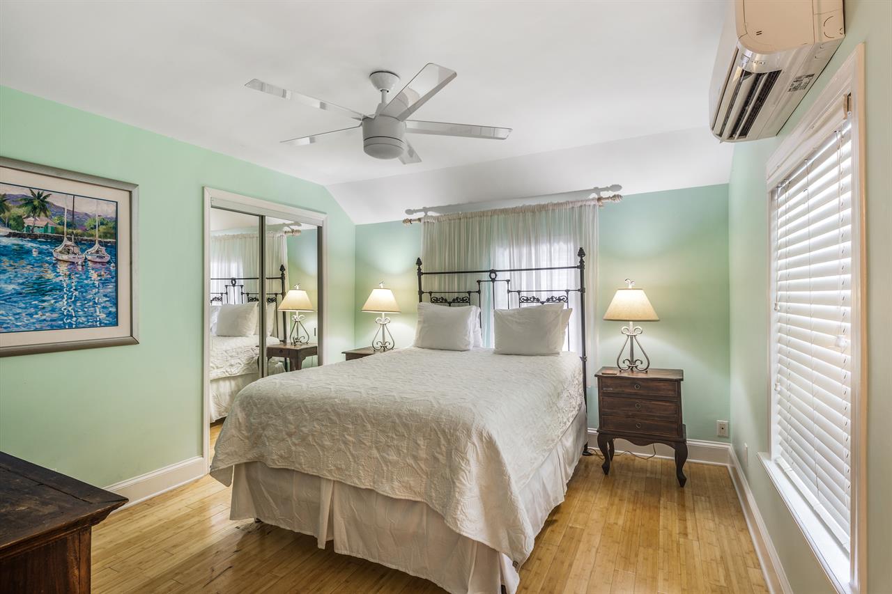 King bed with dresser, closet, and bedside lighting.