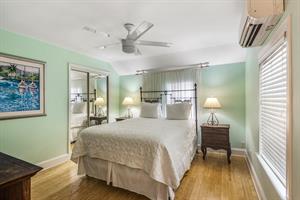 King bed with dresser, closet, and bedside lighting.