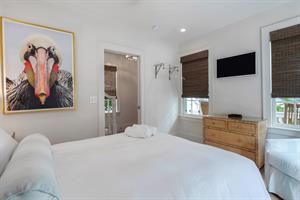 TV, dresser, and plenty of natural light in first floor bedroom