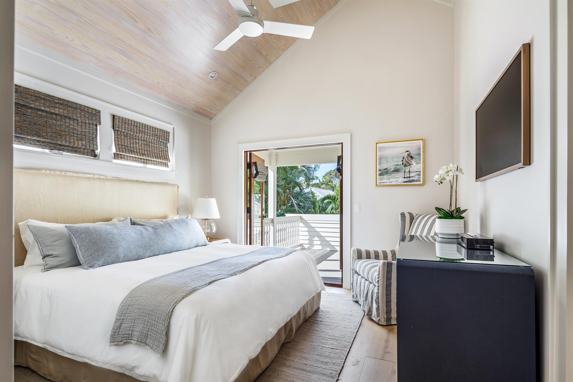 King primary bedroom with private balcony overlooking pool.