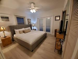 Crisp king bedroom French doors lead directly to the pool area.