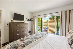 Second king bedroom has dresser, TV, and ceiling fan