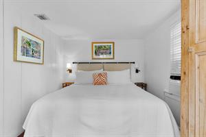 Luxurious linens and sconce lighting in primary bedroom