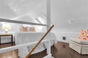Bedside lights and a comfy chair in the loft