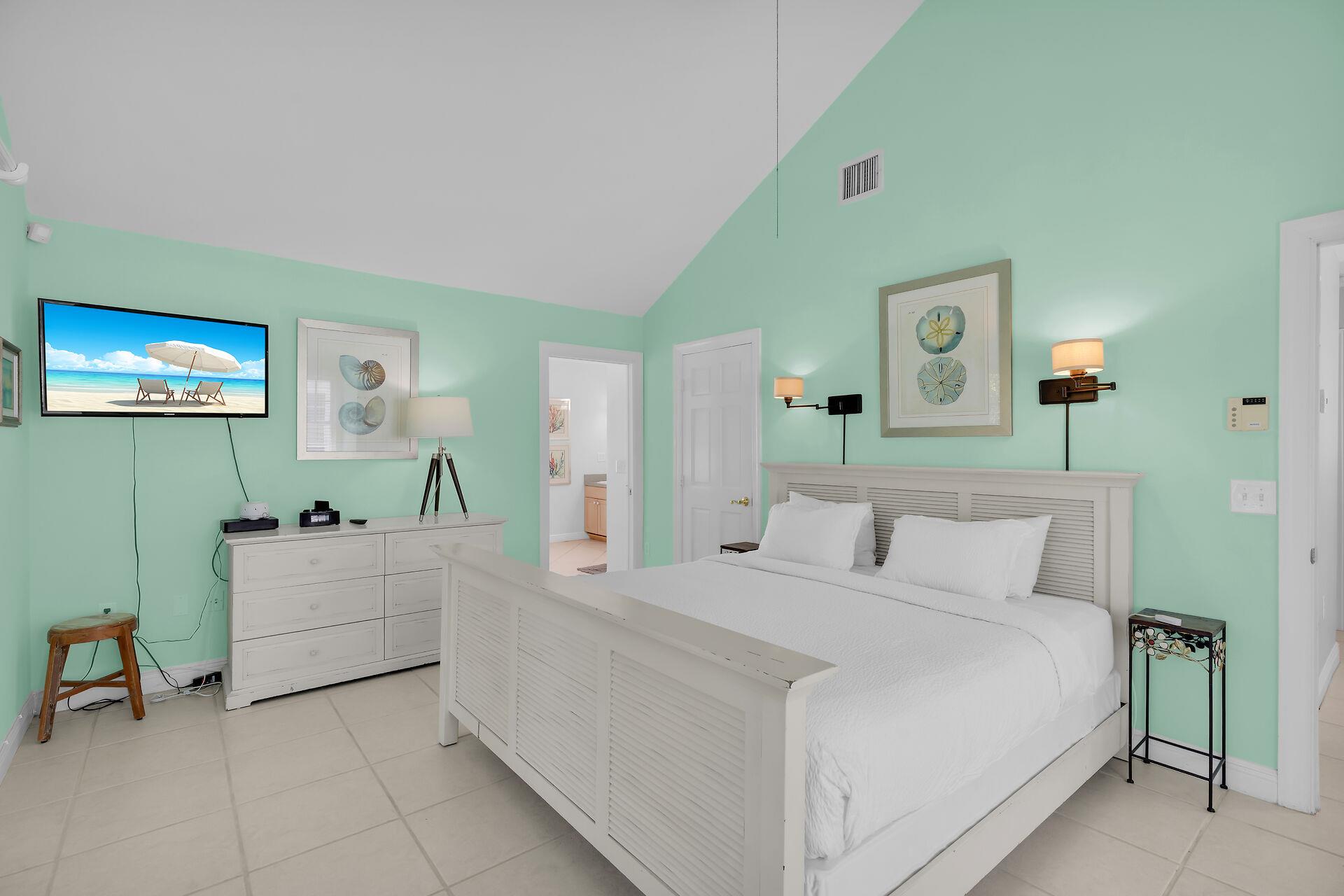 Primary has dresser, TV and vaulted ceiling.