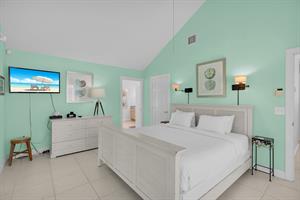 Primary has dresser, TV and vaulted ceiling.