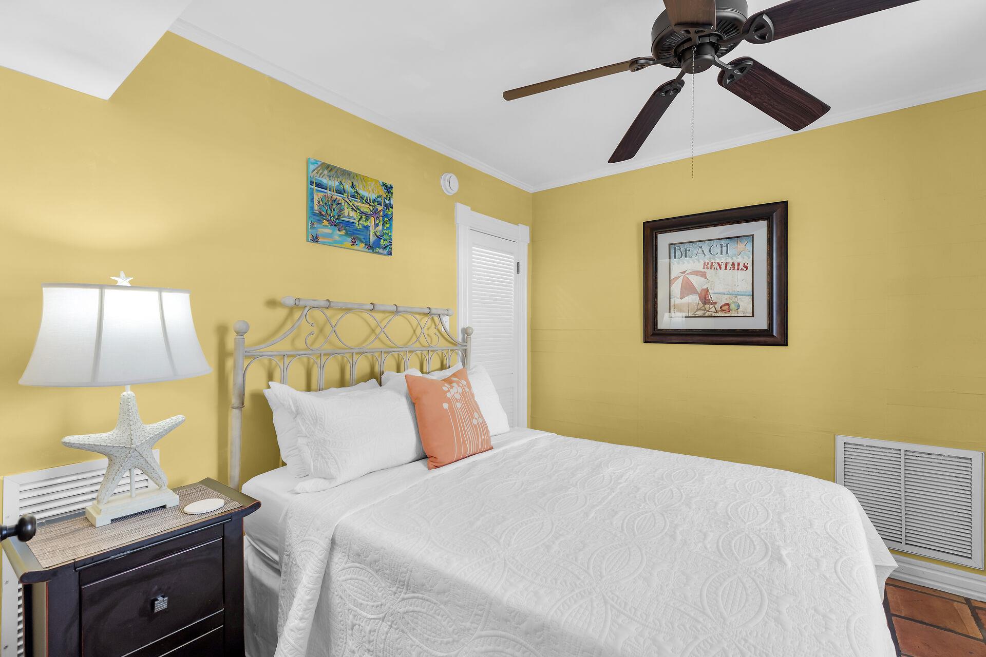Downstairs queen bedroom is cozy and bright.