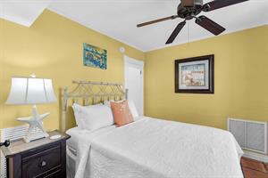 Downstairs queen bedroom is cozy and bright.