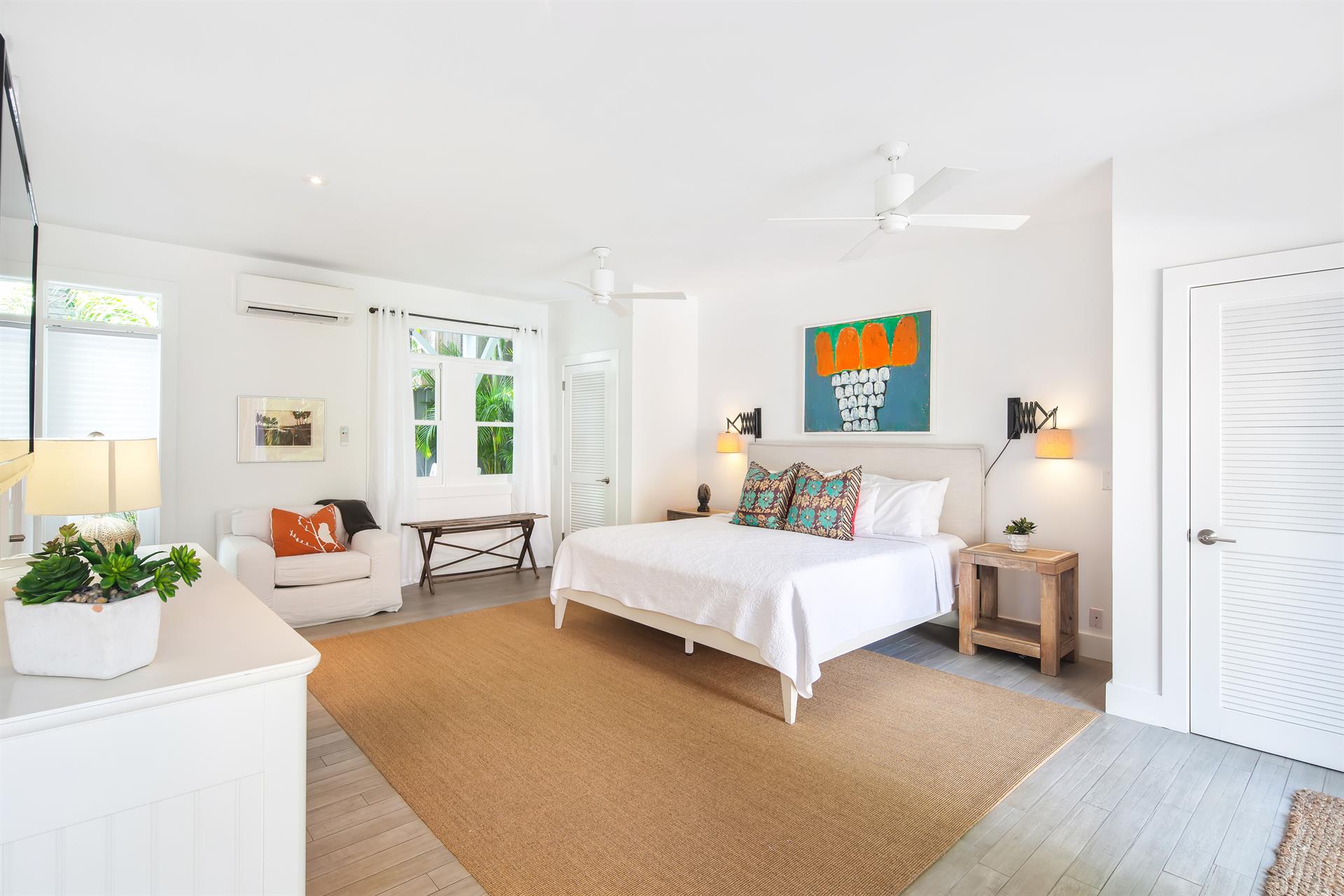 Spacious king bedroom with sitting area, ceiling fan, and closets.