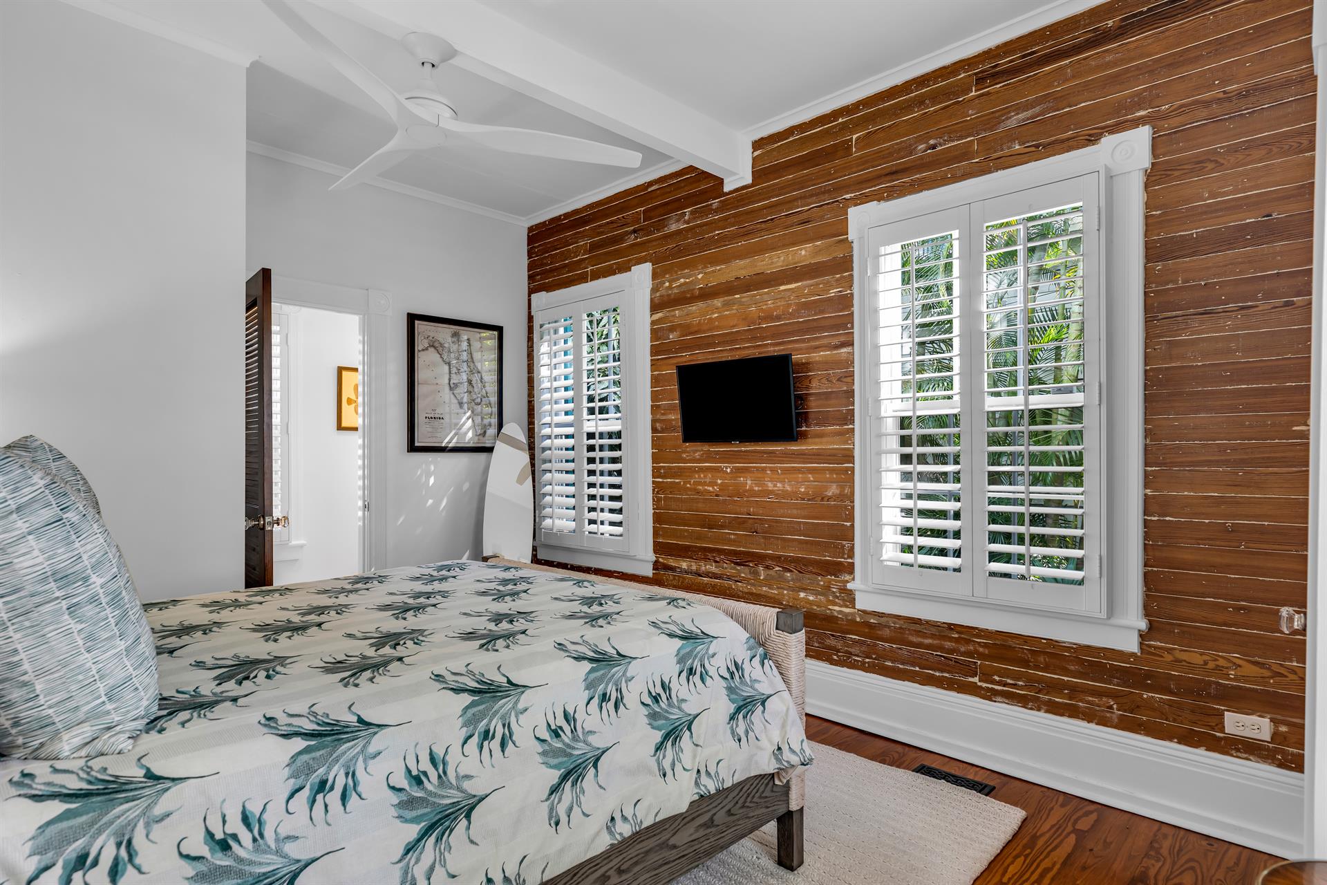 This first floor queen bedroom has a TV and ceiling fan