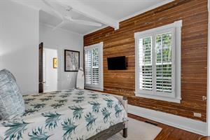 This first floor queen bedroom has a TV and ceiling fan