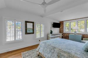 Second floor queen bedroom with dressers and TV