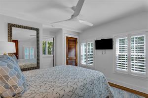 Second floor queen guest bedroom with TV and ceiling fan