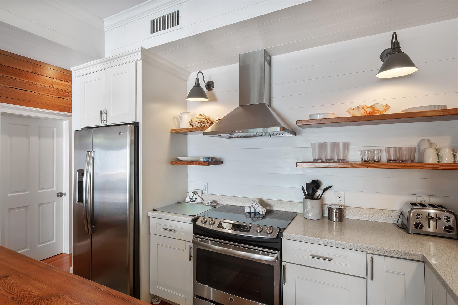 Kitchen boasts open shelving and stainless steel appliances