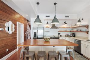 Beautiful kitchen has white granite counter tops and large islan