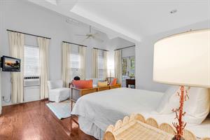 Queen bed with bedside lighting and smart TV.