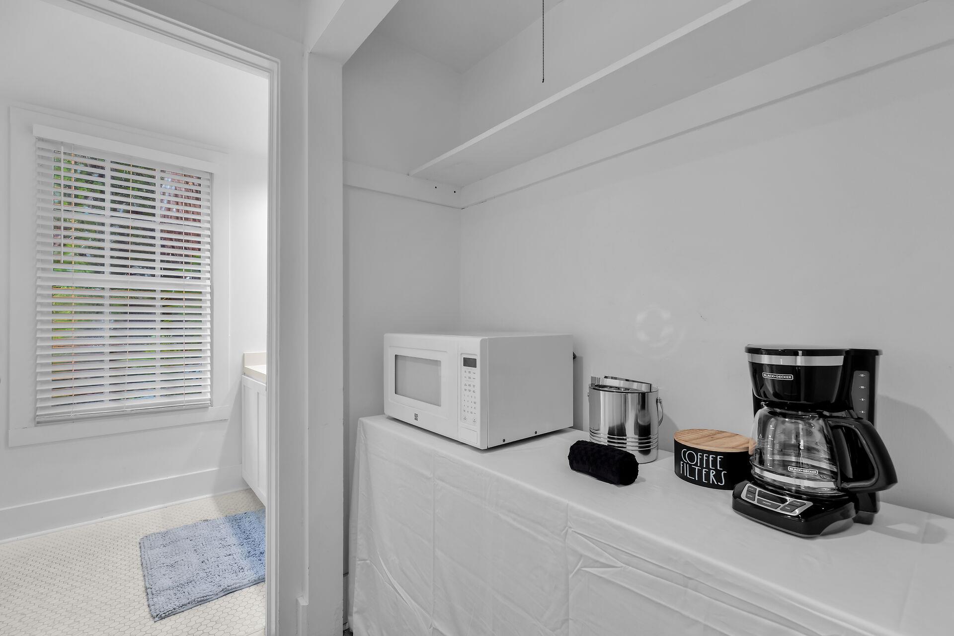Small kitchenette with coffeemaker and microwave.