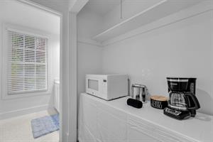 Small kitchenette with coffeemaker and microwave.