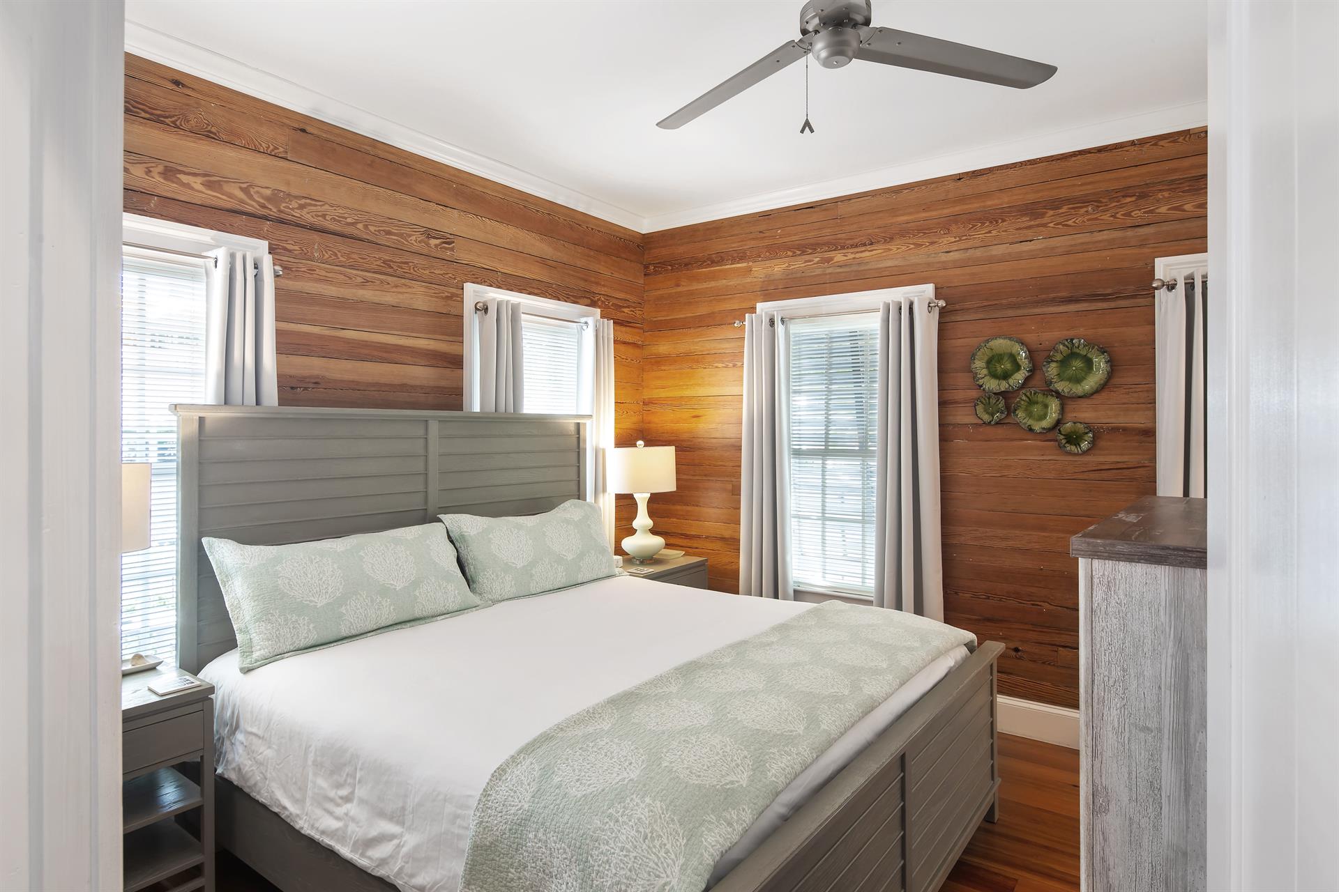 First floor bedroom includes king bed, dresser, and TV
