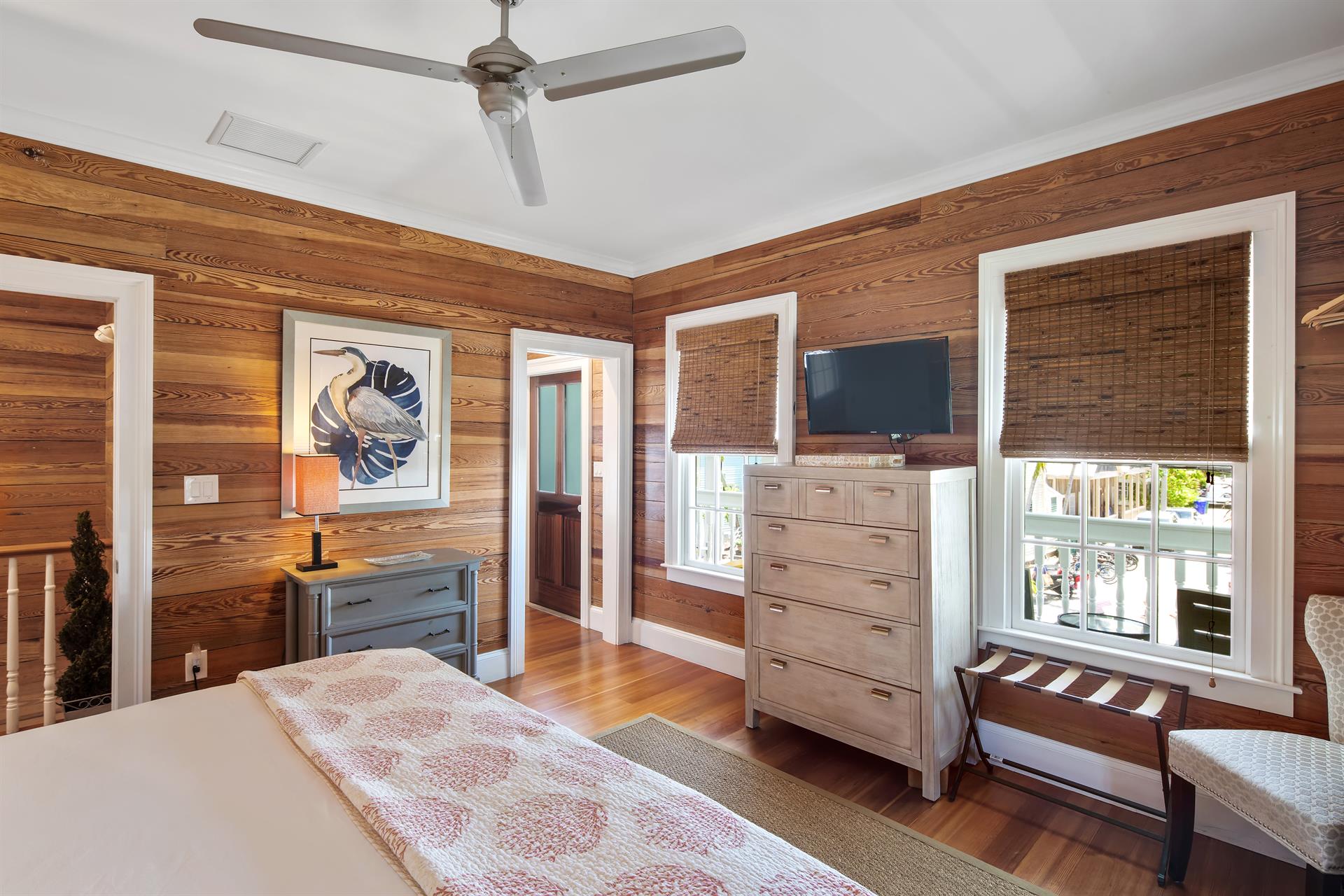 Primary bedroom includes TV, ceiling fan and access to balcony