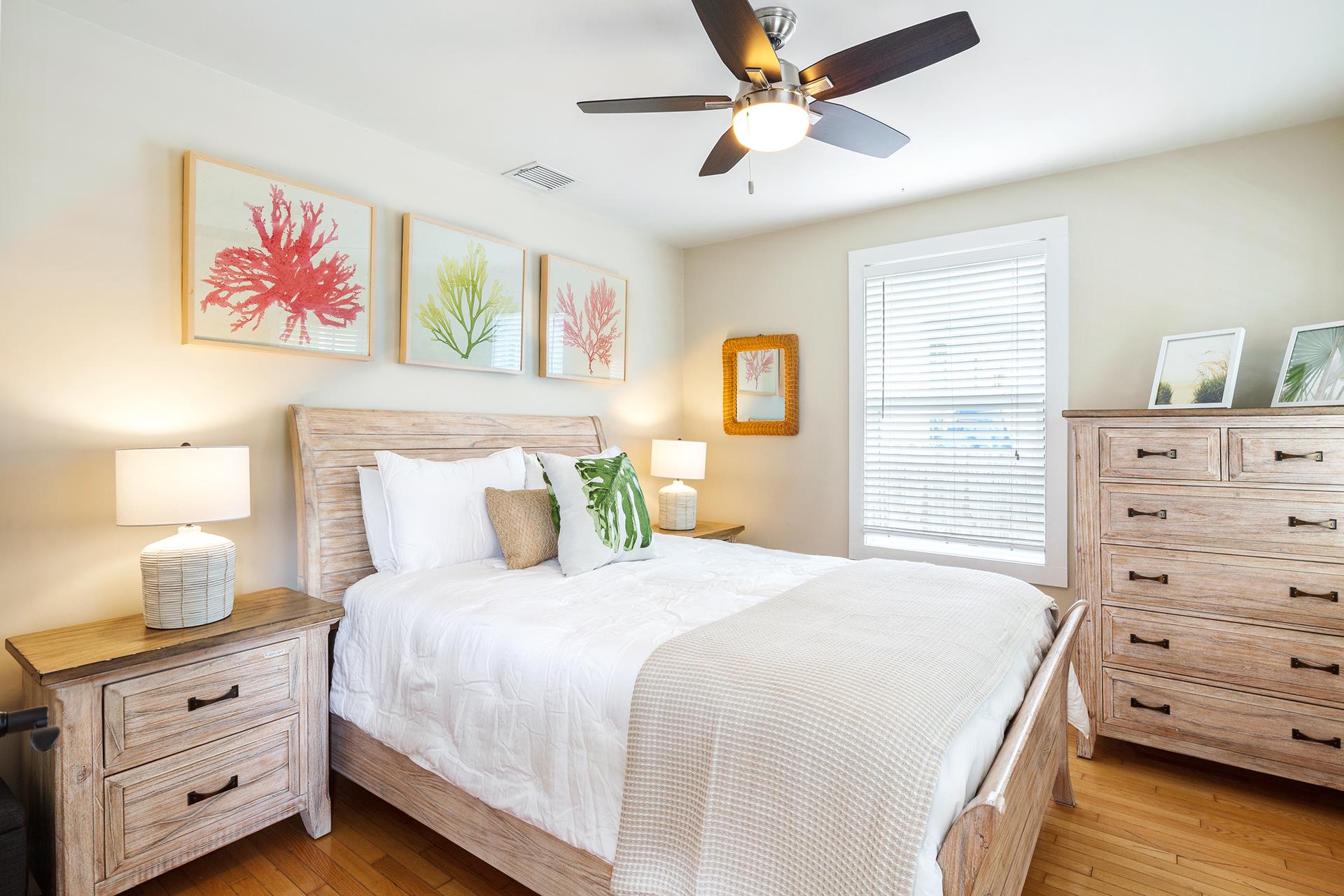 Bright and comfortable queen bedroom with dresser.