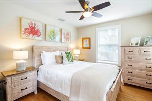Bright and comfortable queen bedroom with dresser.