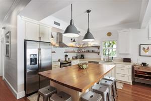 Kitchen includes large butcher block island with seating.