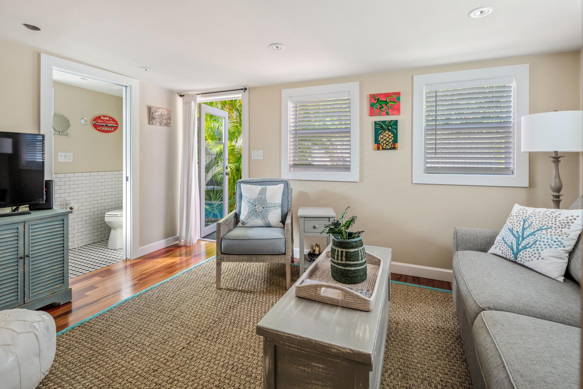 Living room with TV and access to outdoor pool area.