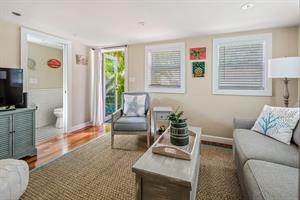 Living room with TV and access to outdoor pool area.