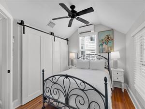 Queen bedroom with sliding barn door closet  vaulted ceiling.