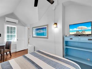 Queen bed with desk, TV  vaulted ceilings.